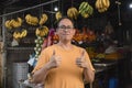 A middle aged Filipino fruit vendor, posing in front of his open-air store, making a thumbs up sign. A small business owner Royalty Free Stock Photo