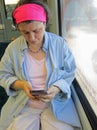 Middle-Aged Woman Looks on her Smartphone in a German Tram