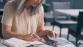 Middle-Aged Good-Looking Asian Woman Is Sitting In The Cafe And Working on The Tablet