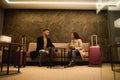 Middle-aged handsome man and pretty woman with suitcases, business partners on a business trip having a conversation in a meeting Royalty Free Stock Photo