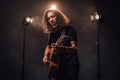 Talanted hispanic musician playing guitar in stage lights