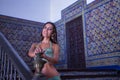 Middle-aged Hispanic woman, in a green dress and rhinestones, to dance belly dancing, leaning on the railing of a staircase. Belly Royalty Free Stock Photo