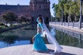 Middle-aged Hispanic woman in turquoise dress with rhinestones, belly dancing with a white veil. Belly dance concept Royalty Free Stock Photo