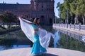 Middle-aged Hispanic woman in turquoise dress with rhinestones, belly dancing with a white veil. Belly dance concept Royalty Free Stock Photo