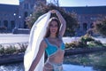 Middle-aged Hispanic woman in turquoise dress with rhinestones, belly dancing with a white veil. Belly dance concept Royalty Free Stock Photo