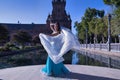 Middle-aged Hispanic woman in turquoise dress with rhinestones, belly dancing with a white veil. Belly dance concept Royalty Free Stock Photo