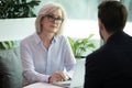 Middle aged hr manager listen male applicant during job interview Royalty Free Stock Photo