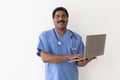 Middle Aged Indian Male Therapist Using Laptop And Smiling At Camera