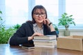 Middle-aged joyful woman with new books unpacked from cardboard box Royalty Free Stock Photo