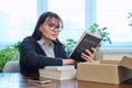 Middle-aged joyful woman with new books unpacked from cardboard box Royalty Free Stock Photo