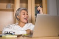 Corporate portrait of attractive and happy successful mature Asian woman working at laptop computer desk smiling confident and Royalty Free Stock Photo