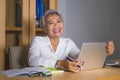 Corporate portrait of attractive and happy successful mature Asian woman working at laptop computer desk smiling confident and Royalty Free Stock Photo