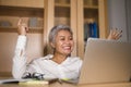 Corporate portrait of attractive and happy successful mature Asian woman working at laptop computer desk smiling confident and Royalty Free Stock Photo