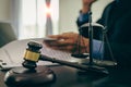 Middle-aged male lawyer working with legal contract documents in court room Justice with tee hammer and black scales on table, Royalty Free Stock Photo