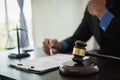 Middle-aged male lawyer working with legal contract documents in court room Justice with tee hammer and black scales on table, Royalty Free Stock Photo