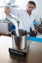 Middle aged male professional with white lab coat pouring sugar Royalty Free Stock Photo