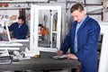 middle-aged male surveyor in coverall working with documents at workshop