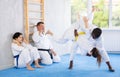 Middle-aged man applying throwing technique on his opponent in sports hall