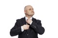 A middle-aged man in a black suit straightens his tie. Isolated on white background