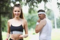 Middle aged man check on young beautiful fit woman running in park Royalty Free Stock Photo