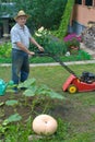 A man in a suburban area with a lawn mower