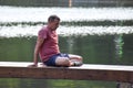 Middle aged man doing yoga asanas. male athlete trains on pier outside park. Royalty Free Stock Photo