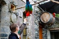 Middle-aged man feeding ara parrots in zoological garden. Man playing and feed trusting friendly birds in zoo and Royalty Free Stock Photo