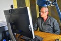 Middle aged man with glasses sitting at desk. Mature man using personal computer. Senior concept