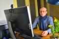 Middle aged man with glasses sitting at desk. Mature man using personal computer. Senior concept. Man and paperwork