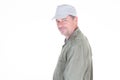 Middle aged man in green shirt and cap smiling profile side view over white background and looking camera Royalty Free Stock Photo