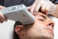 Middle aged man having skin tightening ultrasound facial treatment