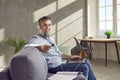 Middle aged man in headphones using laptop at home Royalty Free Stock Photo