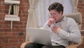 Middle Aged Man with Laptop Coughing on Sofa