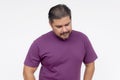 A middle aged man looking disappointed in himself, looking down. Wearing a purple waffle shirt. Isolated on a white background Royalty Free Stock Photo