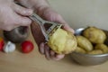 Middle-aged man peels raw potatoes