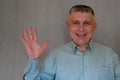 Middle aged man portrait. Open palm gesture of 40 years man looking at camera and smiling. Blue business shirt is dressed. Happy Royalty Free Stock Photo