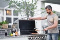 Middle aged man preparing barbecue grill outdoor. Man cooking barbecue grill at backyard. Chef preparing food on Royalty Free Stock Photo