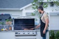 Middle aged man preparing barbecue grill outdoor. Man cooking barbecue grill at backyard. Chef preparing food on Royalty Free Stock Photo