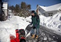 Middle-aged man pushing snow blower Royalty Free Stock Photo