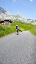 Middle aged man on a red scootor racing down a mountain road in the Alps near Klosters after a rock climbing sessions Royalty Free Stock Photo