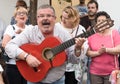 A middle-aged man singing folk songs and plains the guitar during a street concert of the folk choir in Cordoba during the festiva