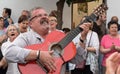 A middle-aged man singing folk songs and playing the guitar during a street concert of the folk choir in Cordoba during the festiv Royalty Free Stock Photo