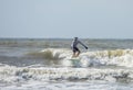 Middle aged man surfs on a longboard in the Atlantic