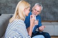 Middle aged man taking care of his wife and bring her medication pills Royalty Free Stock Photo