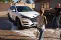 A middle-aged man teaches children of boys 4 and 10 years old to wash a car in the yard of his house on a summer sunny day. 2019. Royalty Free Stock Photo