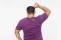 A middle aged man using a backscratcher to scracth and relieve an itch on his upper back. Rear view, isolated on a white