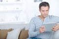 Middle-aged man using digital tablet on sofa Royalty Free Stock Photo