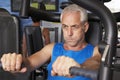 Middle Aged Man Using Weights Machine In Gym