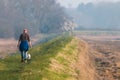 A middle aged man walking his dog off the lead along a rural footpath next to the river Deben in Suffolk Royalty Free Stock Photo