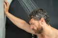 Middle aged man washing hair in bath. Guy bathing shower head in bathtub. Face in foam in shower. Bathing man taking Royalty Free Stock Photo